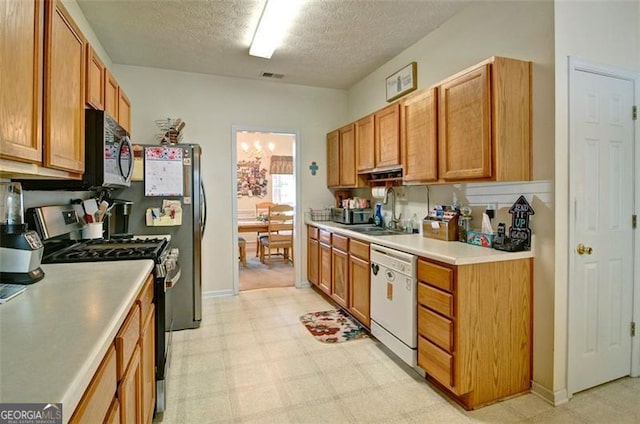 809 Longbranch Ln, Douglasville, GA 30134 - kitchen featuring appliances with stainless steel finishes, a sink, light flooring, light countertops, and a textured ceiling