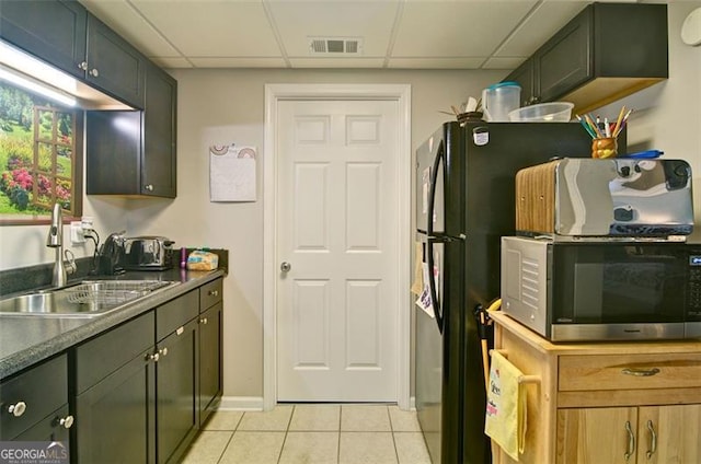 809 Longbranch Ln, Douglasville, GA 30134 - kitchen featuring stainless steel microwave, a sink, light tile patterned flooring, freestanding refrigerator, and a drop ceiling