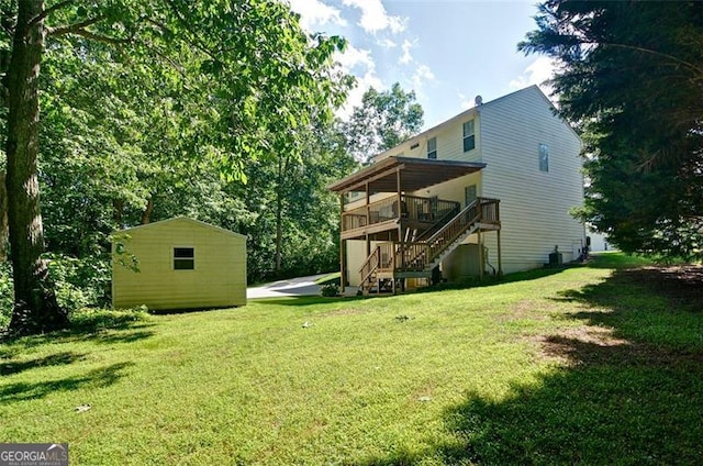 809 Longbranch Ln, Douglasville, GA 30134 - rear view of house featuring stairway, a deck, a lawn, and an outbuilding