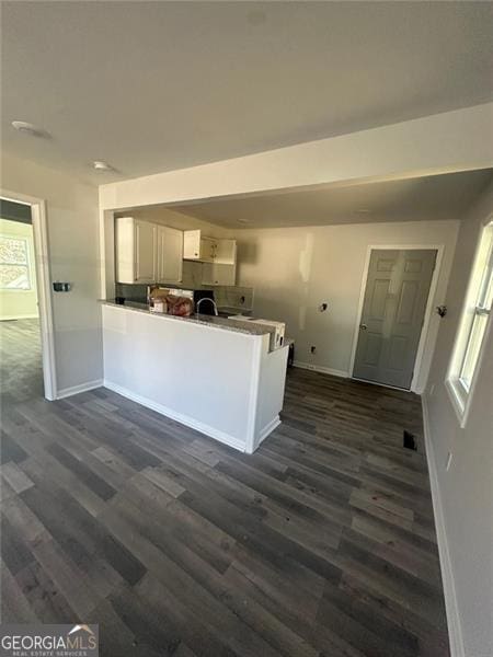 3005 Margaret Dr, Macon, GA 31206 - kitchen with baseboards, a peninsula, and dark wood-type flooring