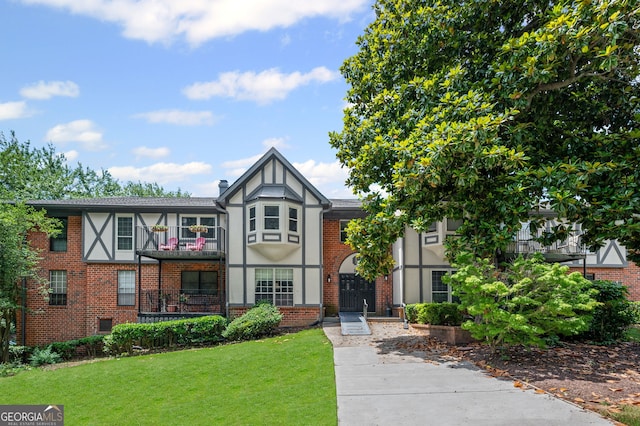 6851 Roswell Rd Unit E4, Sandy Springs, GA 30328 - tudor house featuring a front lawn, stucco siding, brick siding, and a balcony