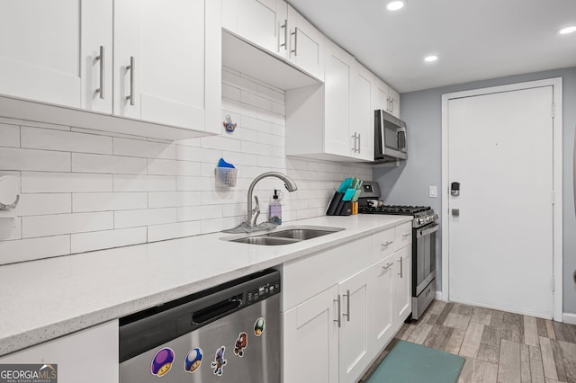 6851 Roswell Rd Unit E4, Sandy Springs, GA 30328 - kitchen featuring stainless steel appliances, a sink, white cabinets, tasteful backsplash, and light wood finished floors