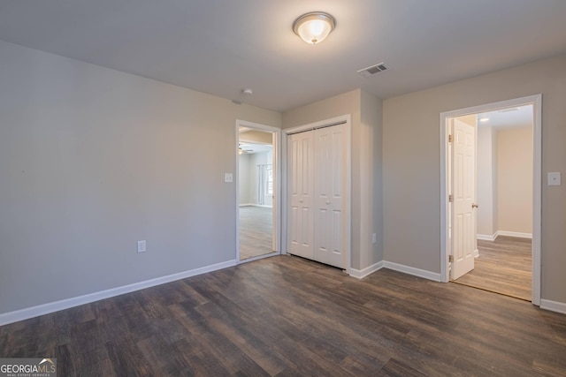 3107 Hendrix Cir SW, Covington, GA 30014 - unfurnished bedroom with baseboards, dark wood-type flooring, and a closet