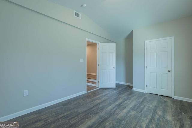 3107 Hendrix Cir SW, Covington, GA 30014 - unfurnished bedroom featuring baseboards, dark wood-style floors, and vaulted ceiling