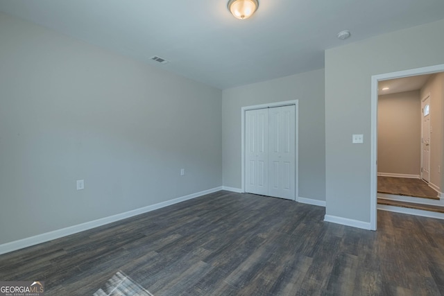 3107 Hendrix Cir SW, Covington, GA 30014 - unfurnished bedroom featuring baseboards, dark wood-style floors, and a closet