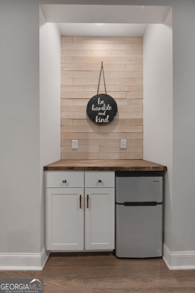 1412 Short Ct, Mcdonough, GA 30252 - detailed view of freestanding refrigerator, baseboards, and wood finished floors