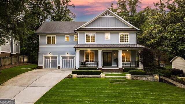 4048 Navajo Trl NE, Brookhaven, GA 30319 - view of front of house featuring a standing seam roof, a porch, a garage, concrete driveway, and board and batten siding