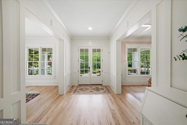 4048 Navajo Trl NE, Brookhaven, GA 30319 - foyer with ornamental molding, a decorative wall, plenty of natural light, light wood-style flooring, and french doors