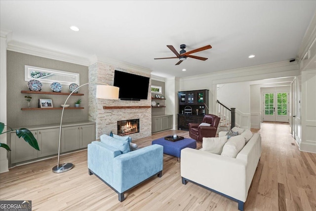 4048 Navajo Trl NE, Brookhaven, GA 30319 - living room featuring a fireplace, ceiling fan, stairs, light wood-style floors, and crown molding