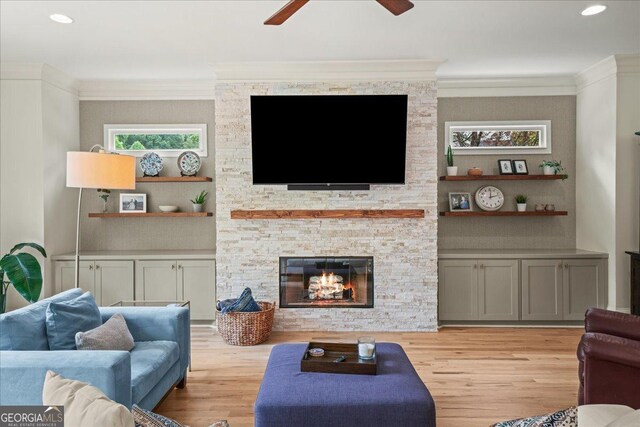 4048 Navajo Trl NE, Brookhaven, GA 30319 - living room featuring ceiling fan, light wood finished floors, a stone fireplace, ornamental molding, and recessed lighting