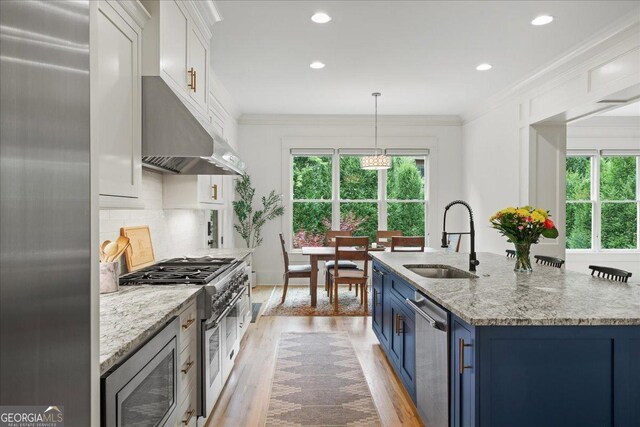 4048 Navajo Trl NE, Brookhaven, GA 30319 - kitchen with stainless steel appliances, under cabinet range hood, light wood-type flooring, tasteful backsplash, and light stone countertops