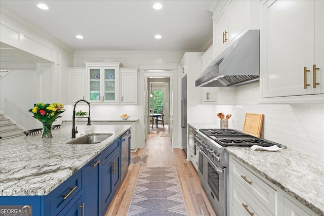 4048 Navajo Trl NE, Brookhaven, GA 30319 - kitchen featuring range hood, a sink, blue cabinets, appliances with stainless steel finishes, and white cabinetry