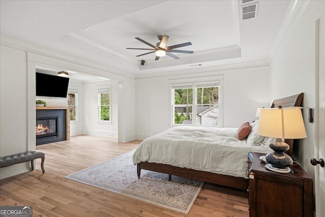 4048 Navajo Trl NE, Brookhaven, GA 30319 - bedroom with a raised ceiling, ornamental molding, wood finished floors, a glass covered fireplace, and ceiling fan