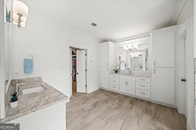 4048 Navajo Trl NE, Brookhaven, GA 30319 - bathroom featuring two vanities, ornamental molding, a chandelier, and a walk in closet