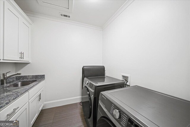 4048 Navajo Trl NE, Brookhaven, GA 30319 - laundry area with separate washer and dryer, cabinet space, crown molding, baseboards, and dark wood-style flooring