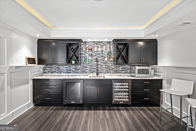4048 Navajo Trl NE, Brookhaven, GA 30319 - bar area with beverage cooler, a tray ceiling, dark wood finished floors, backsplash, and a decorative wall