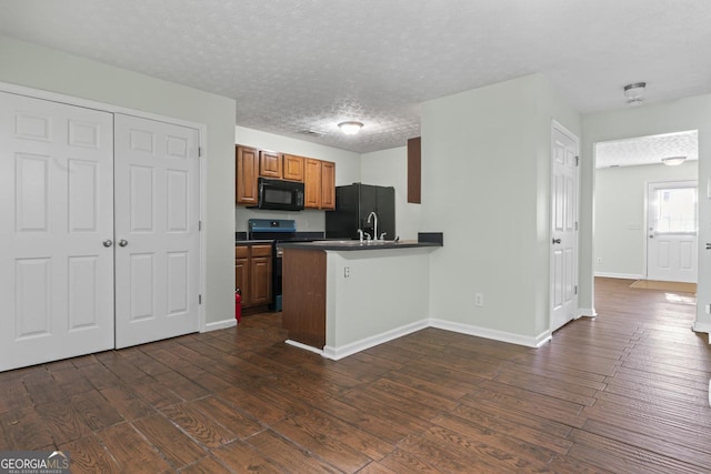 11439 S Grove Dr, Hampton, GA 30228 - kitchen with black appliances, dark wood finished floors, a peninsula, dark countertops, and baseboards