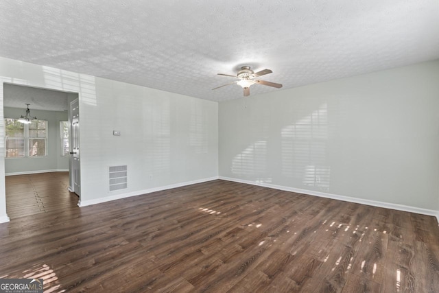 11439 S Grove Dr, Hampton, GA 30228 - empty room with a ceiling fan, dark wood-style floors, a textured ceiling, baseboards, and a chandelier