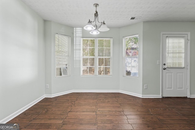 11439 S Grove Dr, Hampton, GA 30228 - unfurnished dining area featuring wood-type flooring, a chandelier, a textured ceiling, and baseboards