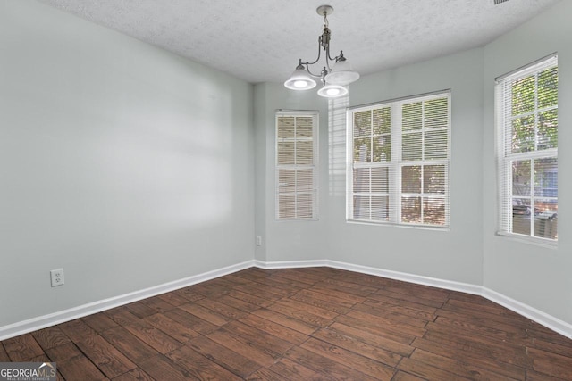11439 S Grove Dr, Hampton, GA 30228 - unfurnished dining area with dark wood-style floors, a chandelier, a textured ceiling, and baseboards