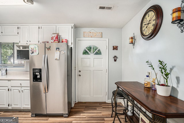 992 Brian Ln, Forest Park, GA 30297 - kitchen with stainless steel fridge, plenty of natural light, and white cabinetry