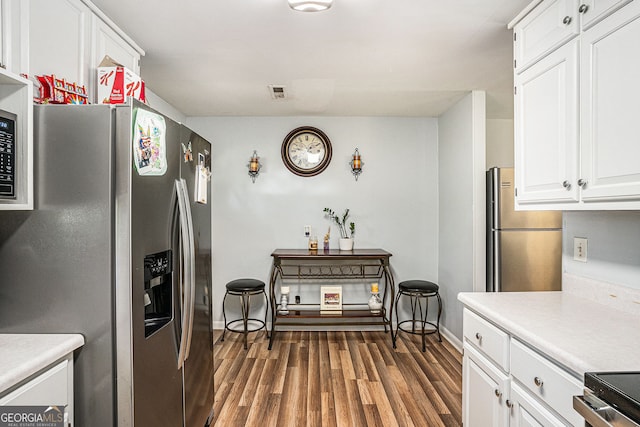992 Brian Ln, Forest Park, GA 30297 - kitchen featuring stainless steel fridge with ice dispenser, freestanding refrigerator, white cabinetry, wood finished floors, and light countertops