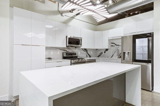 505 Whitehall St SW Unit 102, Atlanta, GA 30303 - kitchen featuring appliances with stainless steel finishes, white cabinetry, light countertops, decorative backsplash, and modern cabinets