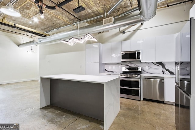 505 Whitehall St SW Unit 102, Atlanta, GA 30303 - kitchen with stainless steel appliances, finished concrete flooring, light countertops, white cabinetry, and decorative backsplash