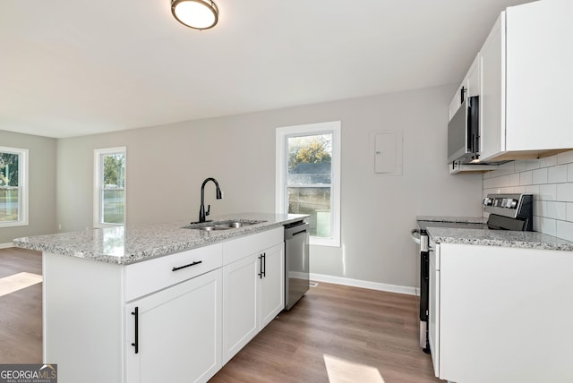 124 Stark St, Commerce, GA 30529 - kitchen featuring appliances with stainless steel finishes, a sink, light stone countertops, backsplash, and light wood finished floors