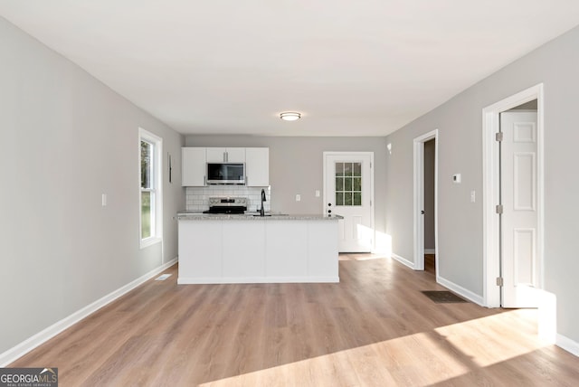 124 Stark St, Commerce, GA 30529 - kitchen with appliances with stainless steel finishes, a sink, light wood-style flooring, baseboards, and white cabinets