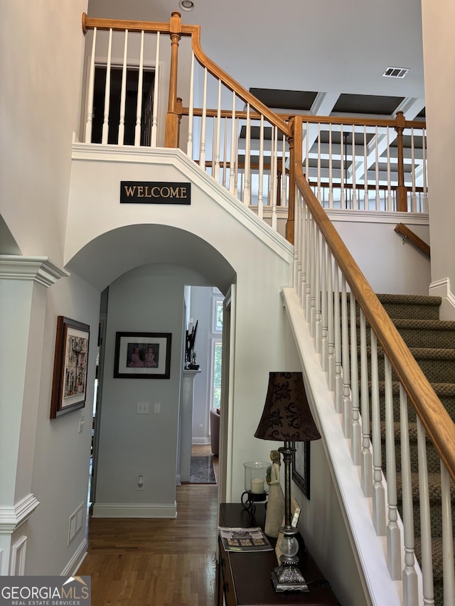 245 River Laurel Way, Woodstock, GA 30188 - stairs featuring arched walkways, wood finished floors, baseboards, and a towering ceiling