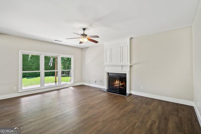 7025 Coffield Ct, Cumming, GA 30041 - unfurnished living room featuring dark wood-type flooring, a large fireplace, ceiling fan, and baseboards