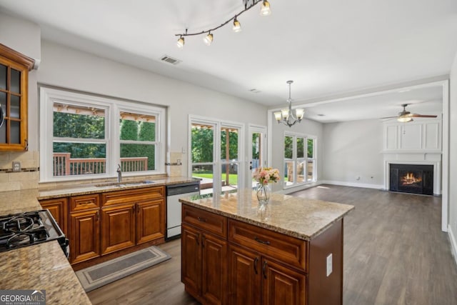 7025 Coffield Ct, Cumming, GA 30041 - kitchen featuring white dishwasher, dark wood-type flooring, a sink, decorative backsplash, and a fireplace