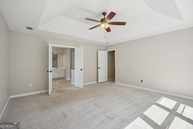7025 Coffield Ct, Cumming, GA 30041 - unfurnished bedroom with a tray ceiling, light colored carpet, baseboards, and ensuite bath