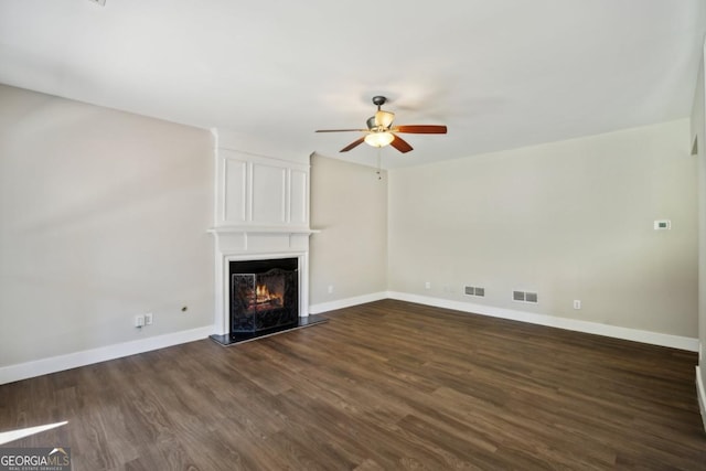 7025 Coffield Ct, Cumming, GA 30041 - unfurnished living room with ceiling fan, dark wood-type flooring, a large fireplace, and baseboards
