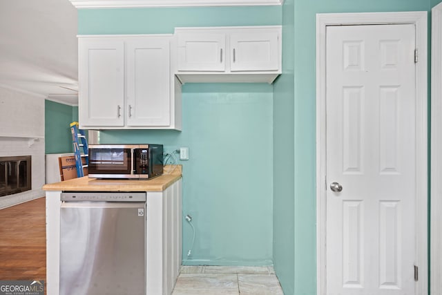 2933 King Alfred Dr, Macon, GA 31204 - kitchen with dishwasher, white cabinetry, crown molding, and a brick fireplace