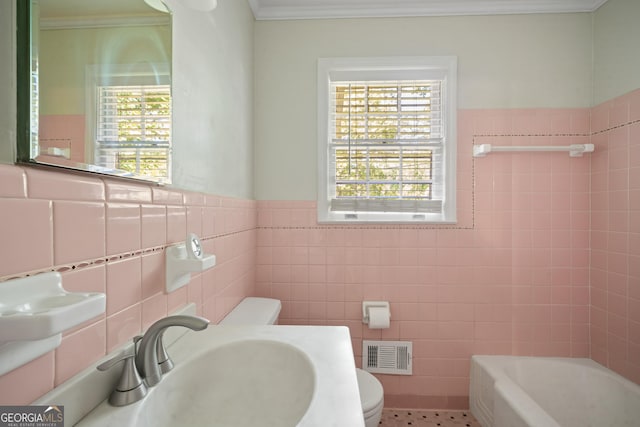 2933 King Alfred Dr, Macon, GA 31204 - bathroom featuring tile walls, toilet, crown molding, a bathtub, and a sink