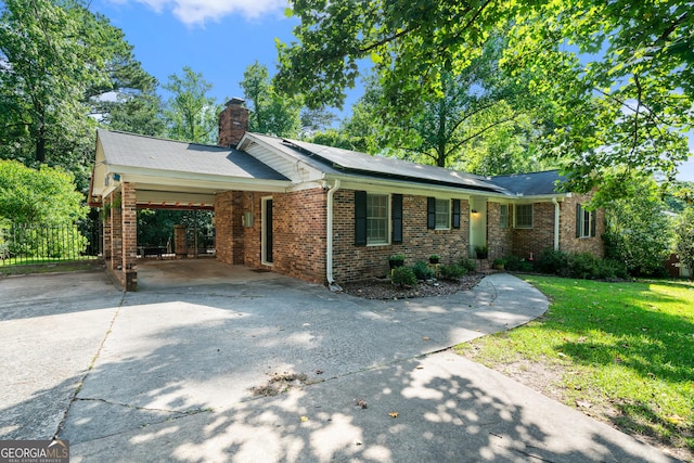 2933 King Alfred Dr, Macon, GA 31204 - ranch-style home featuring driveway, brick siding, a chimney, and roof mounted solar panels