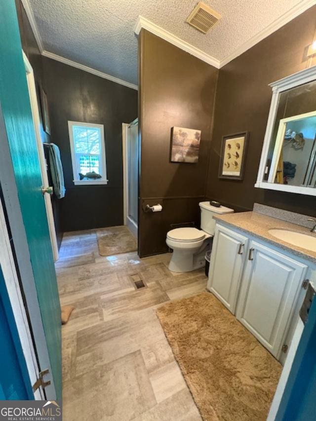 210 Vineyard Rd, Thomaston, GA 30286 - full bathroom with vanity, toilet, a textured ceiling, a stall shower, and ornamental molding