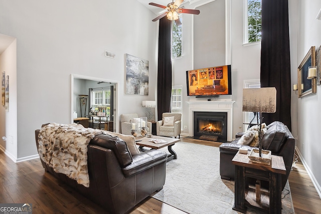 960 Pebblestone Ct, Alpharetta, GA 30009 - living area featuring wood-type flooring, a high ceiling, ceiling fan, a warm lit fireplace, and baseboards