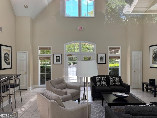 3047 Lenox Rd NE Unit 2105, Atlanta, GA 30324 - living room featuring a towering ceiling, light tile patterned flooring, and baseboards