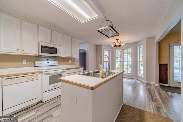 123 Chippewa Run, Auburn, GA 30011 - kitchen with white appliances, a sink, light wood finished floors, white cabinetry, and a textured ceiling