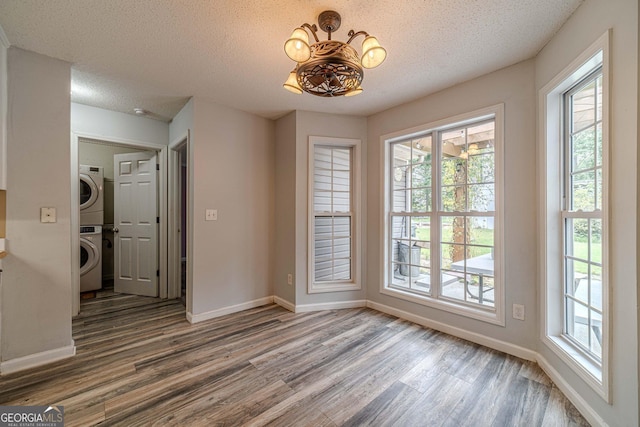 123 Chippewa Run, Auburn, GA 30011 - unfurnished dining area featuring stacked washer / drying machine, wood finished floors, baseboards, and a textured ceiling