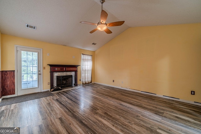 123 Chippewa Run, Auburn, GA 30011 - unfurnished living room with dark wood-style floors, a ceiling fan, a high end fireplace, vaulted ceiling, and a textured ceiling