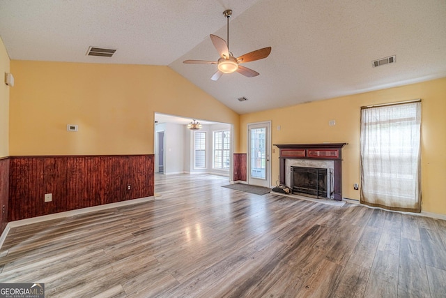 123 Chippewa Run, Auburn, GA 30011 - unfurnished living room with ceiling fan, wood finished floors, a fireplace, wainscoting, and a textured ceiling