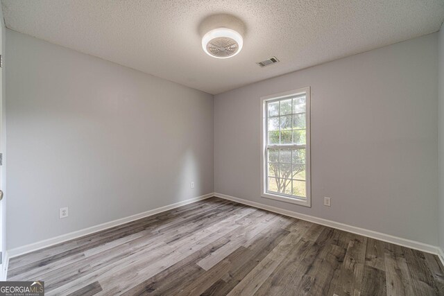 123 Chippewa Run, Auburn, GA 30011 - unfurnished room featuring wood finished floors, baseboards, and a textured ceiling