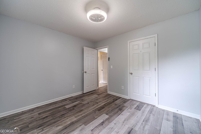 123 Chippewa Run, Auburn, GA 30011 - unfurnished bedroom featuring wood finished floors, baseboards, and a textured ceiling