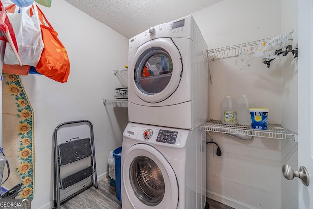 123 Chippewa Run, Auburn, GA 30011 - laundry area with stacked washing machine and dryer, wood finished floors, baseboards, a textured ceiling, and heating unit