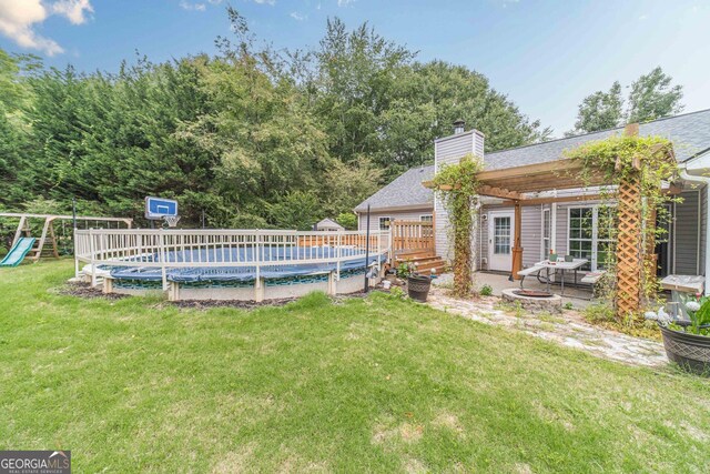 123 Chippewa Run, Auburn, GA 30011 - view of grassy yard featuring a wooden deck, a playground, and a patio