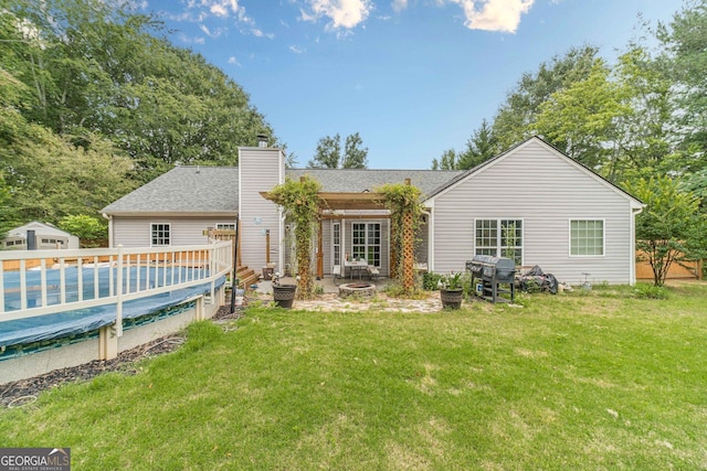 123 Chippewa Run, Auburn, GA 30011 - back of house featuring a lawn, a fire pit, a chimney, a deck, and a covered pool